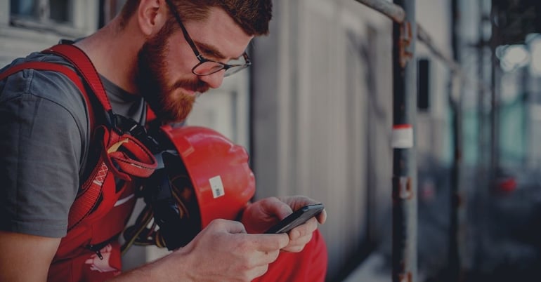 an oilfield services technician looking at data on a smartphone